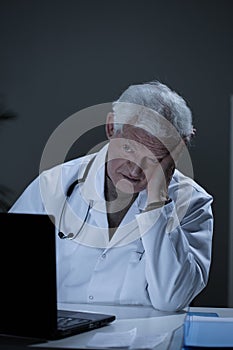 Depressed practitioner working in office photo