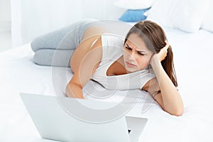 Depressed Pregnant Woman Works at Laptop Computer While Lying on