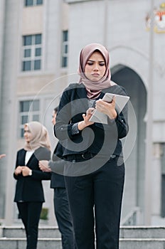 Depressed and sad expression face of  young business woman standing while looking at her tablet