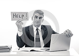 Depressed sad and frustrated middle aged businessman holding a help sign