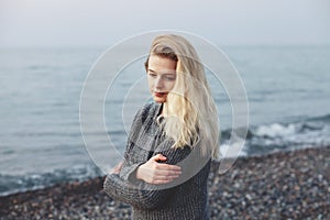 depressed sad frustrated young vulnerable woman standing at sea shore