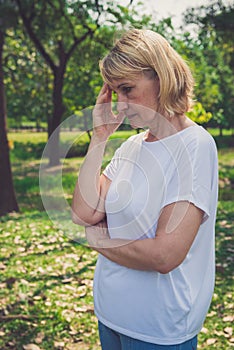 Depressed and sad old woman in park