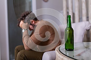 Depressed sad young addicted man feeling bad drinking beer alone at home, stressed frustrated lonely drinker alcoholic suffer from