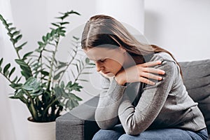 Depressed sad young female sitting on couch in living room, expression to face difficulty, failure and exhausted. Worried upset