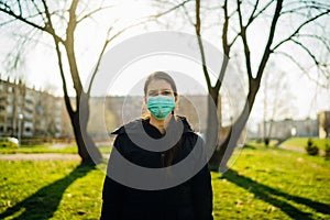 Depressed scared person wearing a mask to prevent contracting disease in spring nature.Coronavirus pandemic life.Panic and fear of