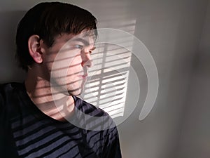 Depressed Shut-in Looking Outside from Behind Window Blinds, Lost, Alone, Regret, Dejected, Sad, Consumed, Broken photo