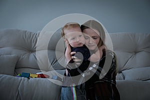 Depressed single mother hugging her child in living room