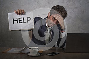 Depressed and stressed attractive hispanic man in suit and tie working overwhelmed office computer desk holding notepad asking for