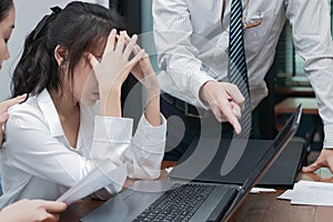 Depressed stressed young Asian business woman covering face suffering hand`s boss in office