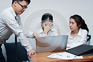 Depressed stressed young Asian business woman covering face suffering hand`s boss in office