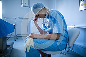 Depressed surgeon sitting on a chair