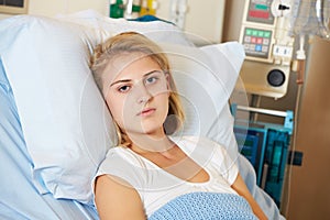 Depressed Teenage Female Patient Lying In Hospital Bed