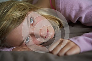 Depressed Teenage Girl Lying In Bedroom