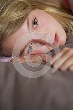 Depressed Teenage Girl Lying In Bedroom