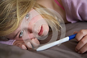 Depressed Teenage Girl Sitting In Bedroom