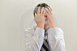 depressed teenager boy covered his face with his hands