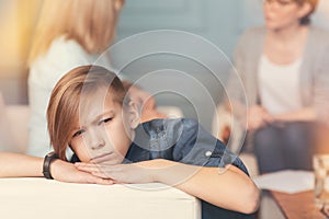 Depressed teenager boy sitting in the office of a professional psychologist