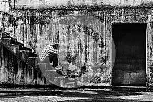 Depressed teenager sitting on stair in creepy abandoned building