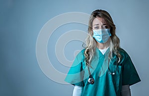 Depressed and tired female Doctor or Nurse Wearing Protective Medical Face Mask portrait