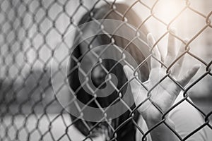 Depressed, trouble, help and chance. Hopeless women raise hand on chain-link fence ask for help