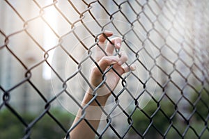 Depressed, trouble and solution. Women hand on chain-link fence.