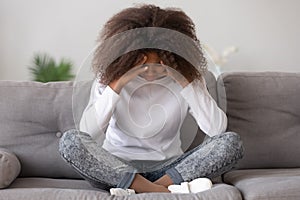 Depressed upset african american teen girl feeling hurt sitting alone