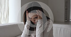 Depressed upset young woman suffering from headache.