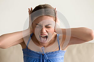 Depressed woman closing ears and screaming