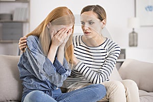 Depressed woman comforted by friend