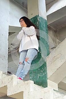 Depressed woman crying in abandoned building