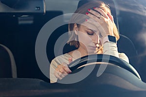 Depressed woman driver sitting in her car, feeling emotional burnout after work