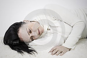 Depressed woman lying on floor