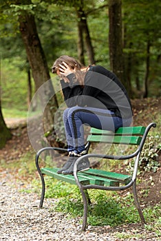 Depressed woman sitting on banch