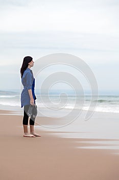 Depressed woman watching the sea in a deserted beach