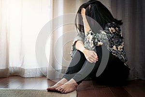 Depressed women sitting near curtain in living room, alone, sadness, emotional concept