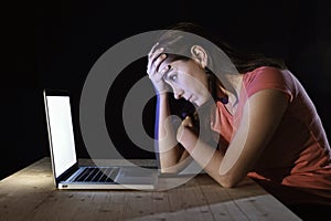 Depressed worker or student woman working with computer alone late night in stress