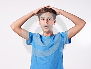 Depressed young boy holding his hands over head.