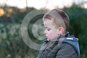 Depressed young child outside in field