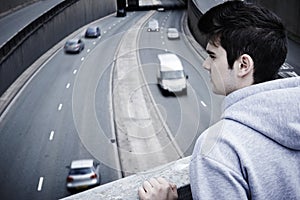 Depressed Young Man Contemplating Suicide On Road Bridge