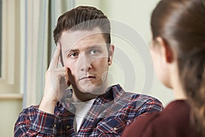 Depressed Young Man Talking To Counsellor