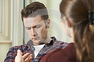 Depressed Young Man Talking To Counsellor