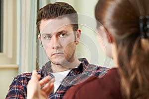 Depressed Young Man Talking To Counsellor