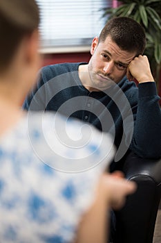 Depressed Young Man Talking To Counselor