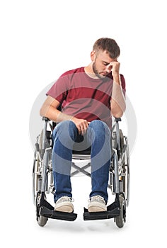 Depressed young man in wheelchair on white background