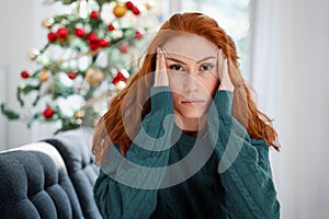 Depressed young red haired woman on christmas holiday