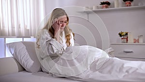 Depressed young woman crying in bed, pain of relative loss, grief and sorrow photo