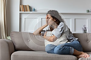 Depressed young woman crying at home feeling stressed