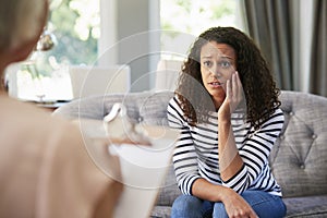 Depressed young woman having therapy with a psychologist