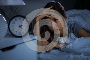 Depressed young woman lying in bed cannot sleep from insomnia