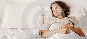 Depressed young woman lying on the pillow on bed at home, depression insomnia and mental problems